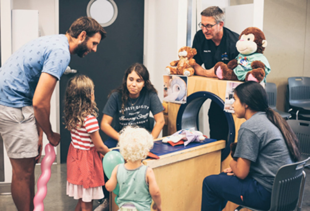Children and medical professionals model an MRI procedure